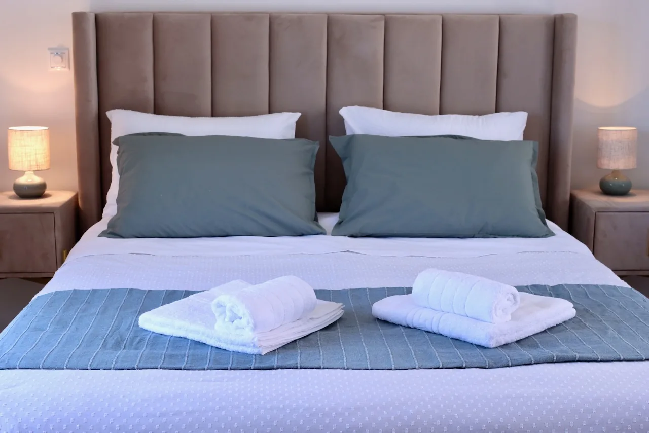 Comfortable double bed with soft lighting and fresh towels