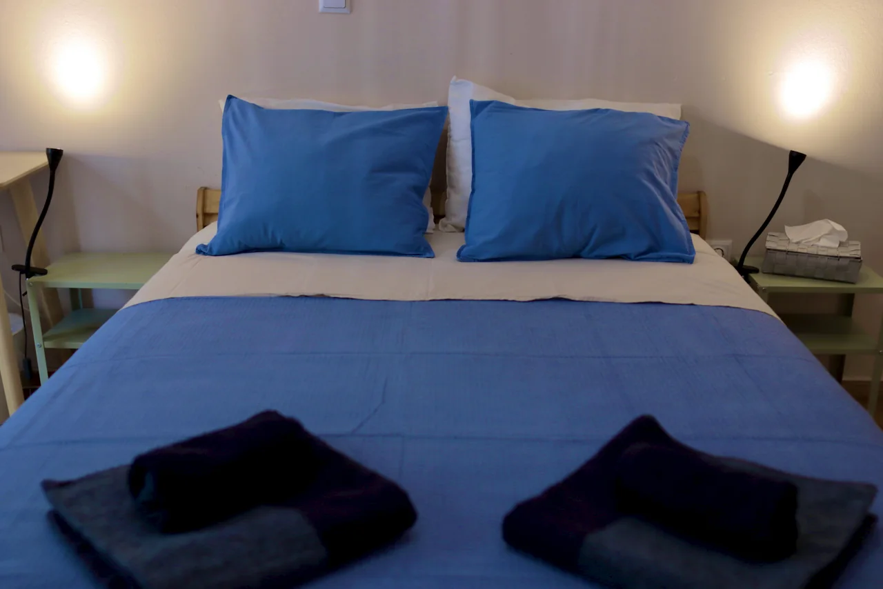 Separate bedroom with double bed and blue pillows