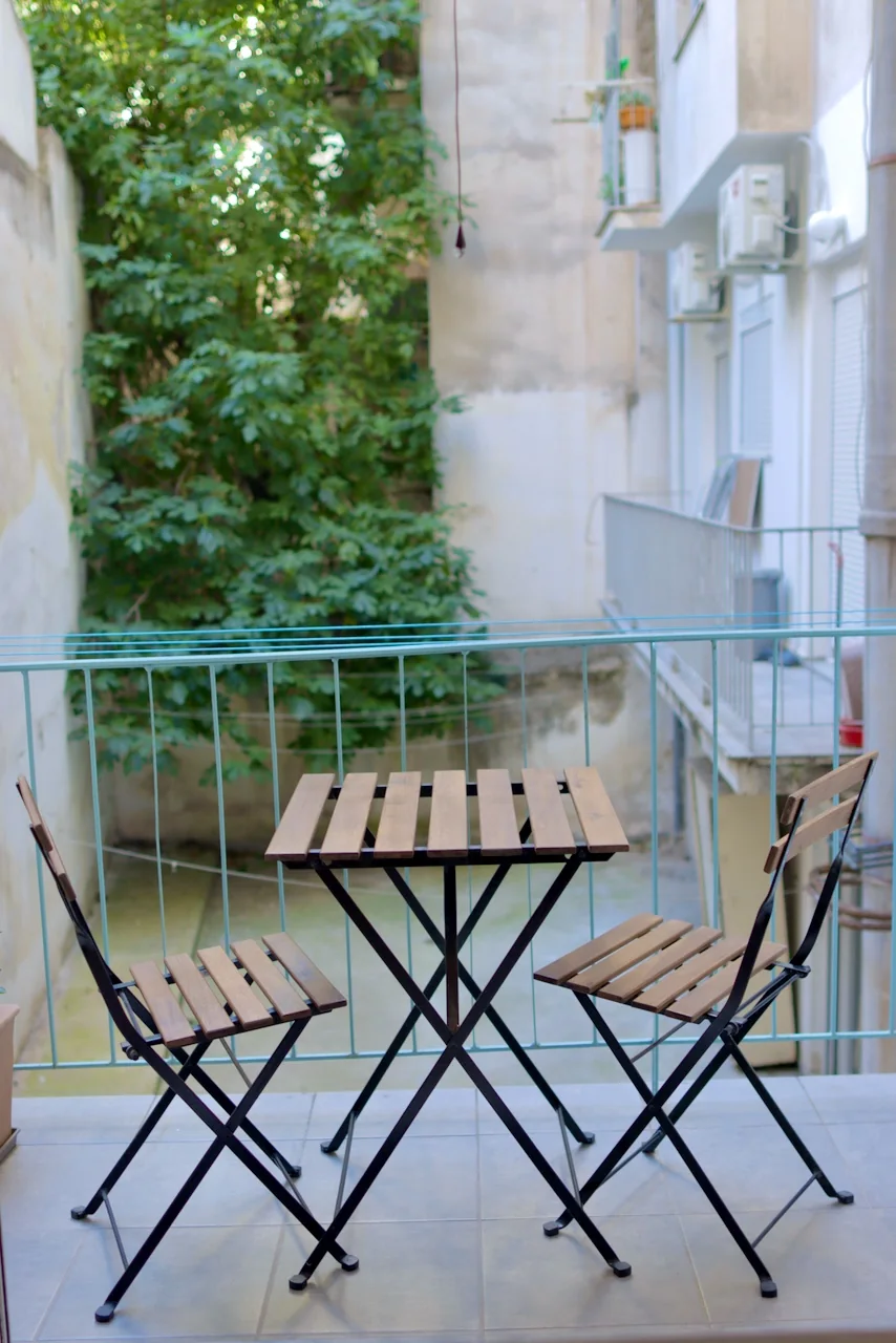 Private balcony with bistro table and greenery