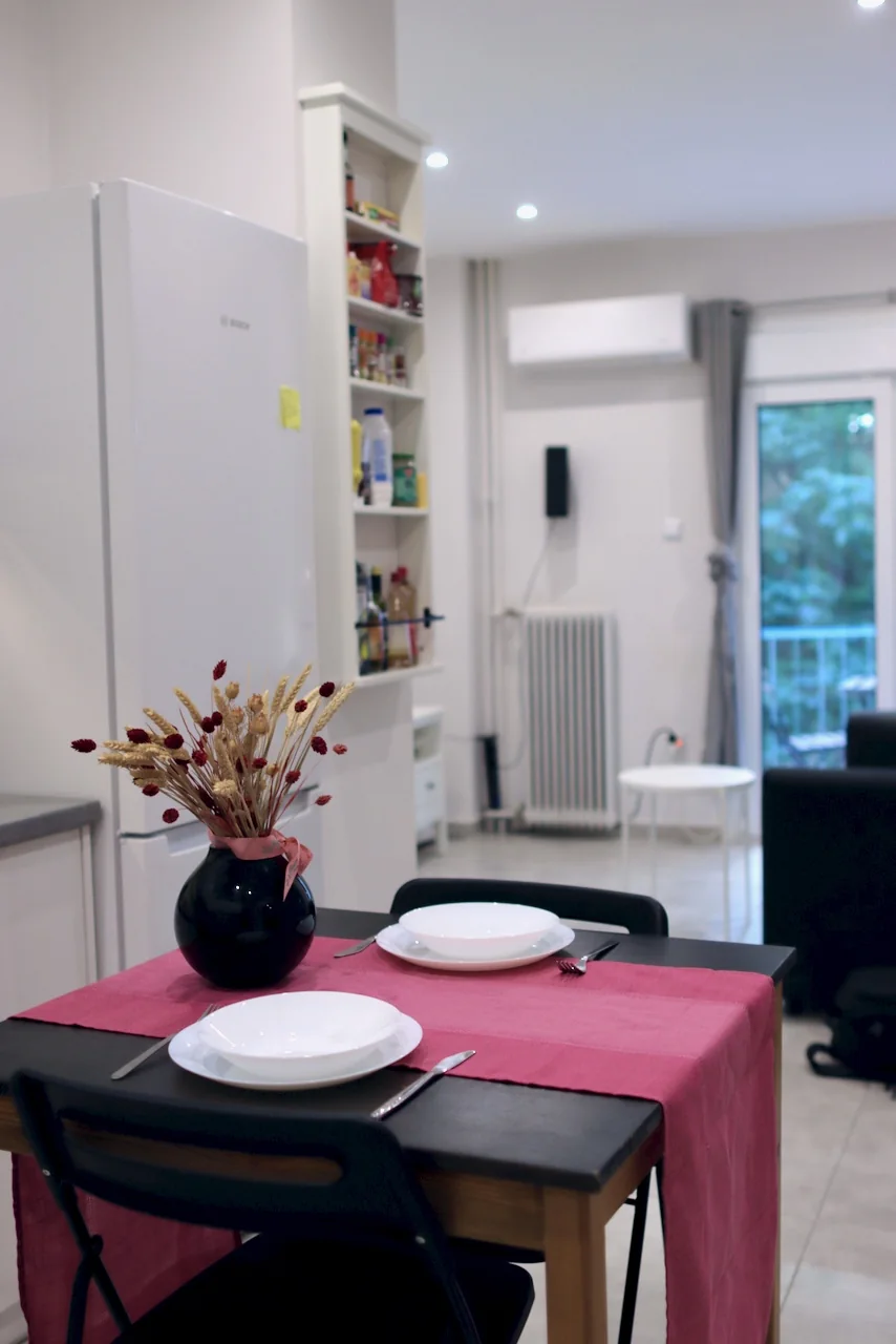 Dining table and kitchen ready for a stay in Kypseli