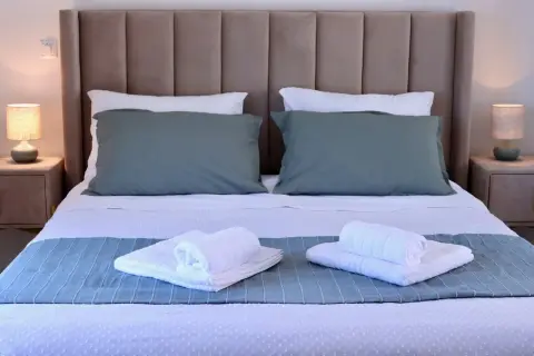 Comfortable double bed with soft lighting and fresh towels
